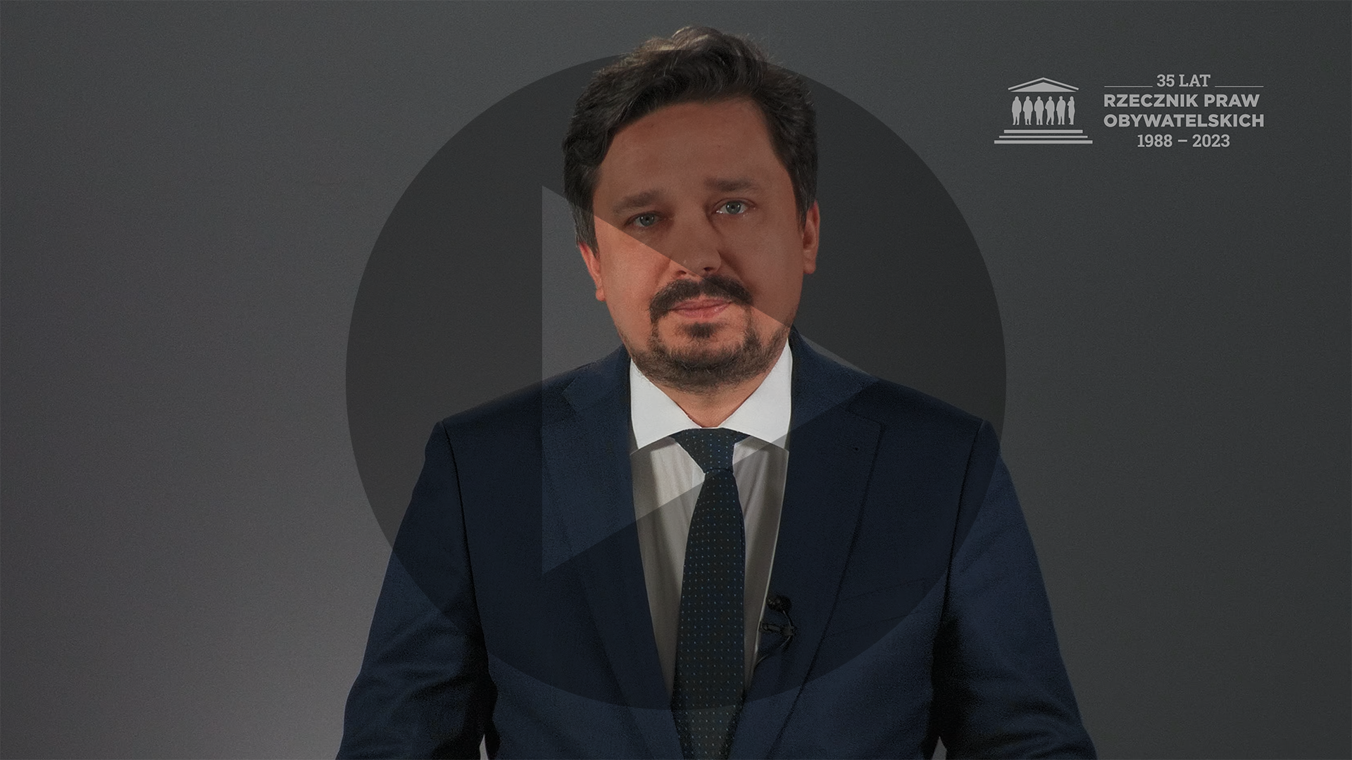 Kadr z nagrania przedstawiający RPO Marcina Wiącka z naniesionym symbolem odtwarzania wideo