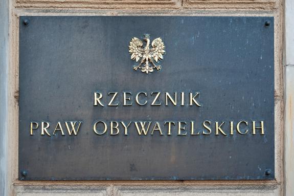 Tablica z ciemnego kamienia z orłem w koronie i napisem "Rzecznik Praw Obywatelskich" w złotym kolorze
