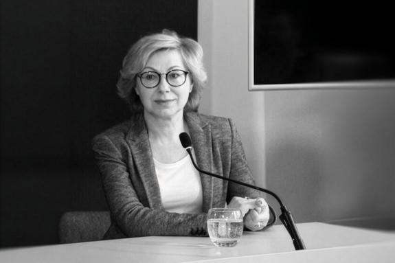 Czarno-białe zdjęcie Jolanty Florek siedzącej przy stole konferencyjnym