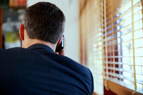 Plecy mężczyzny w garniturze rozmawiającego przez telefon