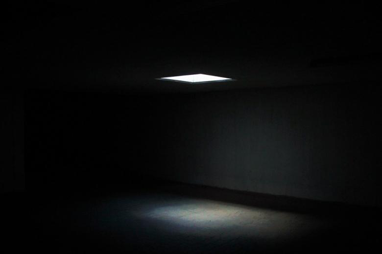 zdjęcie snopu światła padającego z góry w ciemnym pomieszczeniu