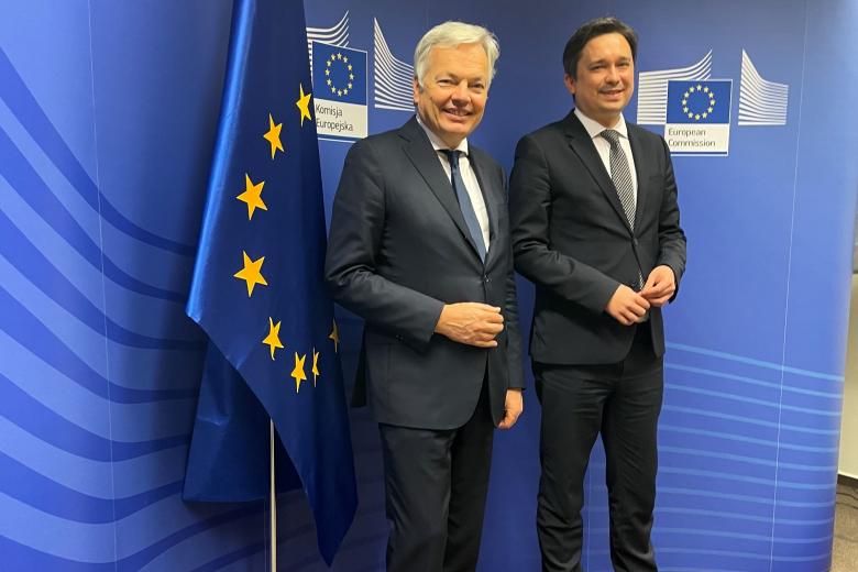 dwóch mężczyzn na tle ścianki w barwach UE