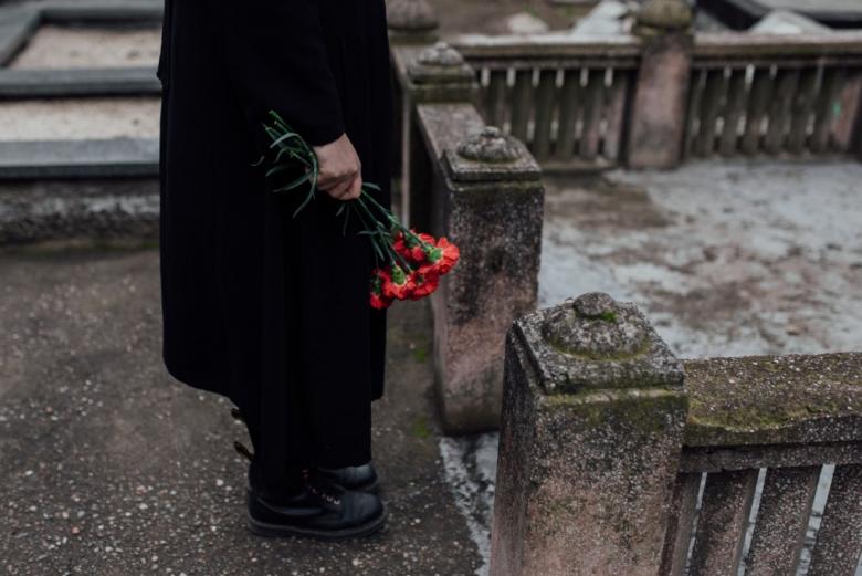 osoba z kwiatami na cmentarzu 