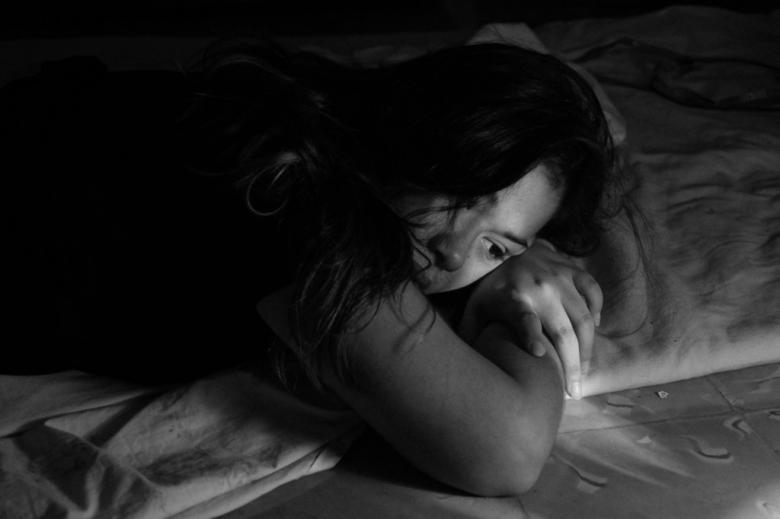 Zdjęcie kobiety z twarzą wtuloną w poduszkę 