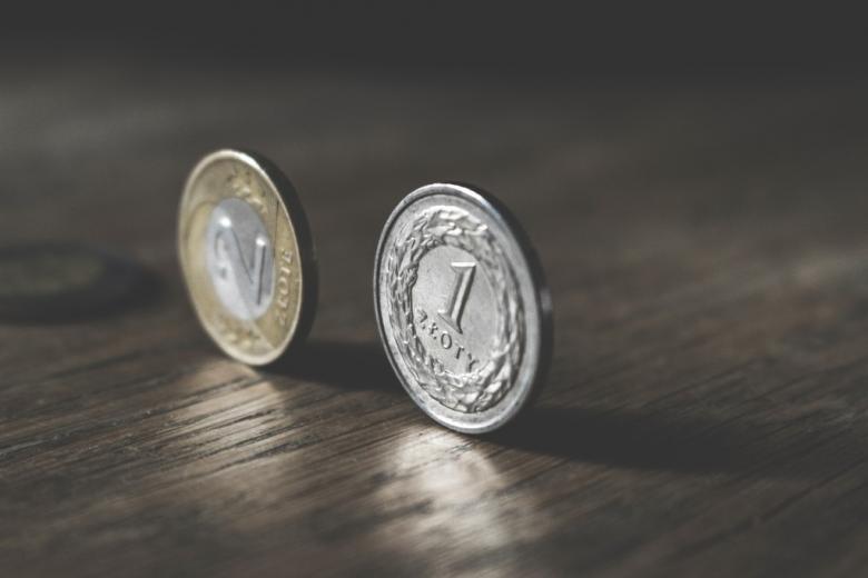 Zdjęcie dwóch monet postawionych na sztorc na podłodze
