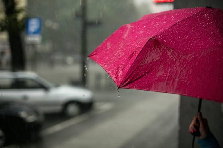 zdjęcie osoby z parasolem w deszczową pogodę 