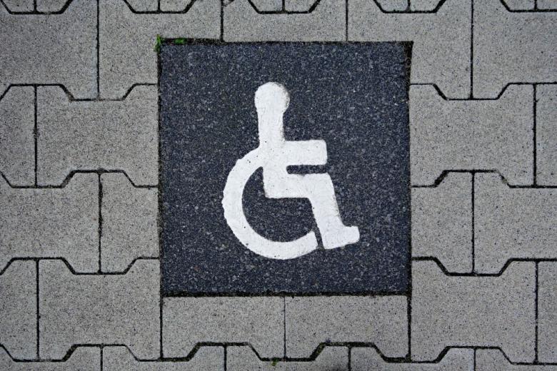 grafika z symbolem osoby z niepełnosprawnością na wózku