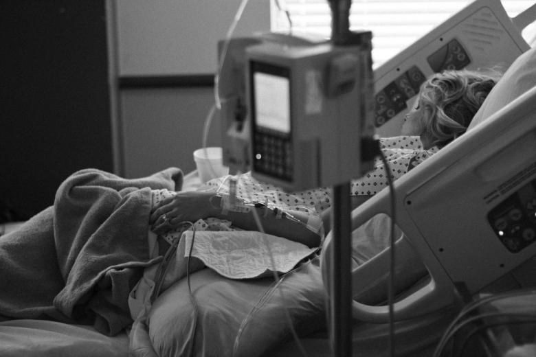 zdjęcie kobiety w szpitalnym łóżku na oddziale intensywnej terapii
