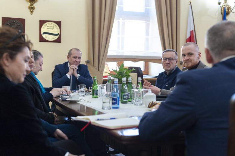 Członkowie delegacji BRPO oraz przedstawiciele miasta Jarosław rozmawiają siedząc przy stole w urzędowym gabinecie