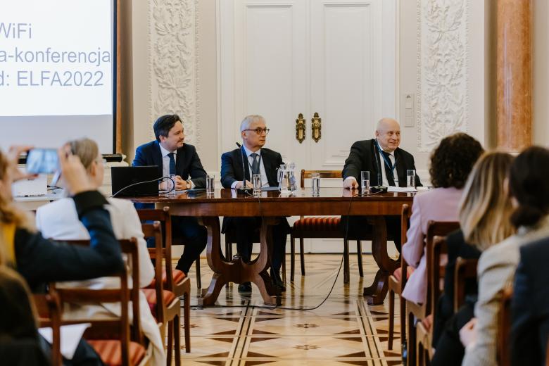 RPO Marcin Wiącek siedzący w panelu przy stole razem z innymi ekspertami. Na pierwszym planie rzędy widowni słuchającej dyskusji.