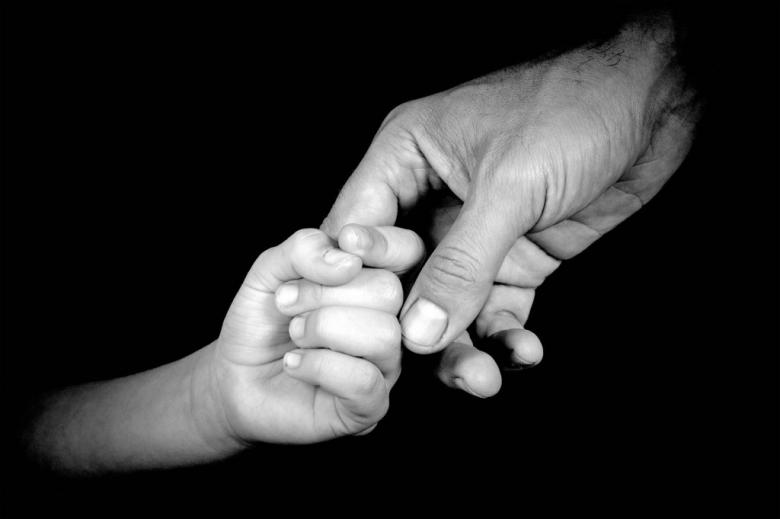 zdjęcie piąstki dziecka trzymającej palec rodzica