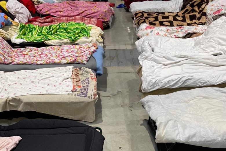 Miejsca do spania w hali Global EXPO - łóżka polowe z kolorową pościelą