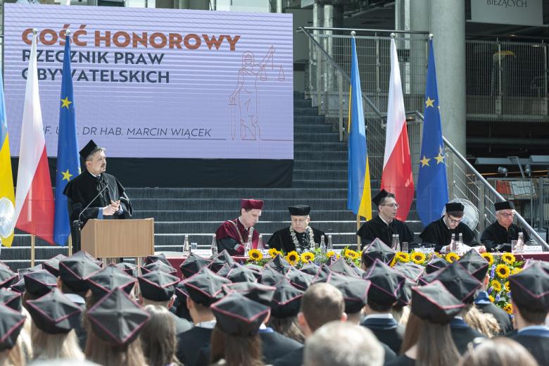 RPO Marcin Wiącek w todze uczelnianej przemawia na podium na zakończeniu roku akademickiego na WPiA UW