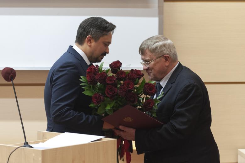RPO Marcin Wiącek wręcza bukiet czerwonych kwiatów prof. Marianowi Grzybowskiemu