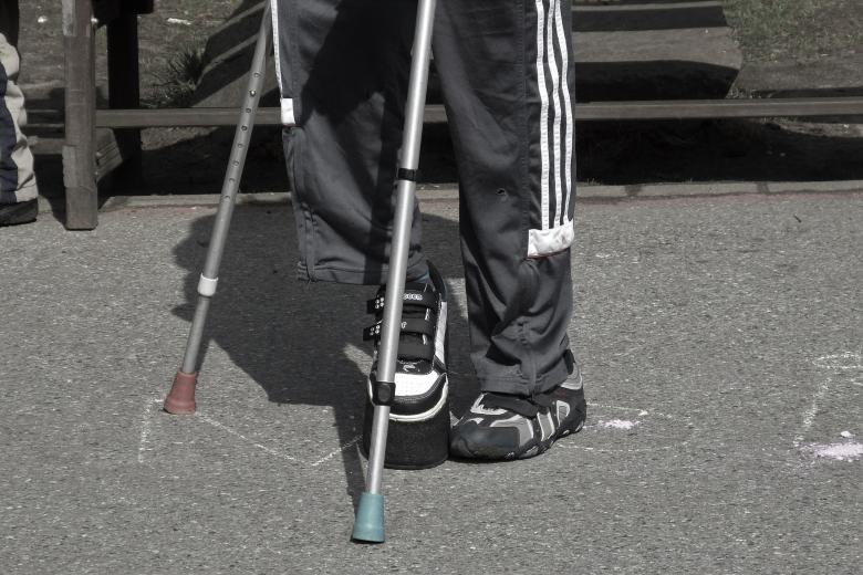 osoba stojąca o kulach z niepełnosprawnością nogi 