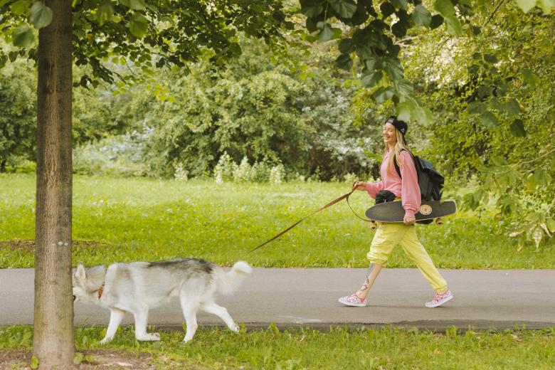 Kobieta spacerująca z psem na smyczy w parku