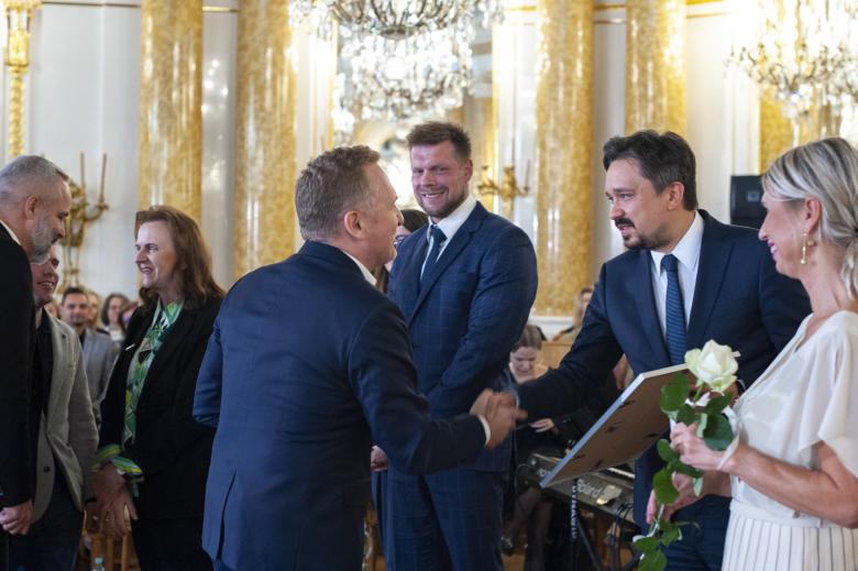 RPO Marcin Wiącek uściskiem dłoni gratuluje jednemu z laureatów 