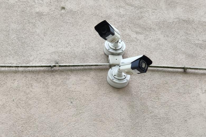 Dwie kamery monitoringu zamontowane do ściany skierowane w przeciwnych kierunkach