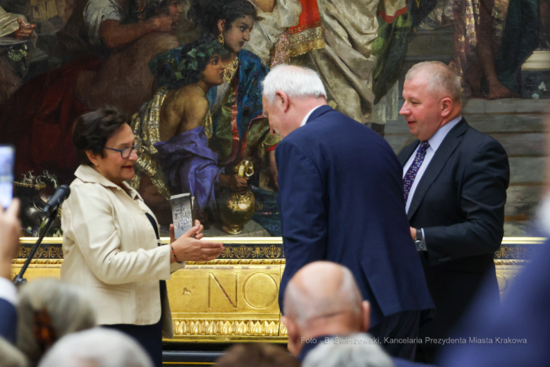 ZRPO Hanna Machińska otrzymuje statuetkę nagrody z rąk dwóch mężczyzn w garniturach