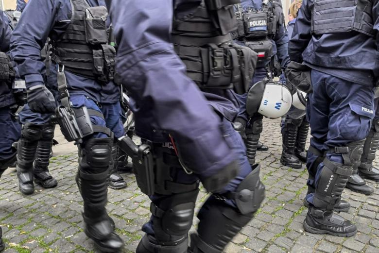 policja w specjalnym rynsztunku, w kamizelkach kuloodpornych, z bronią, kaskami i ochraniaczami 