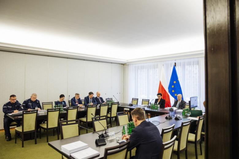 W sali posiedzeń komisji, przy podkowiastym stole konferencyjnym, siedzą członkowie Komisji i przedstawiciele biura RPO. Za stołem stoją flagi Polski i Unii Europejskiej