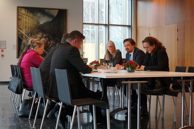 RPO Marcin Wiącek oraz ambasadorzy siedzą po dwóch stronach dużego stołu i rozmawiają