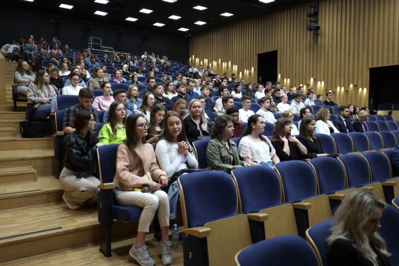 Kilkudziesięciu studentów siedzących na dużej auli wykładowej