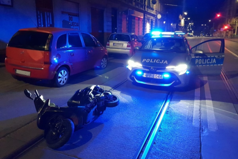 skuter leży na ulicy w mieście nocą przed radiowozem  Po policyjnym pościgu Fot. chorzow.policja.gov.pl