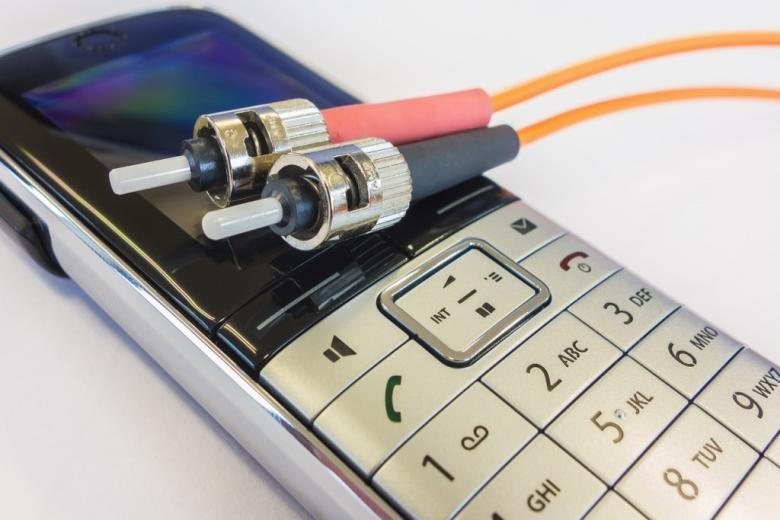 telefon komórkowy na którym lezą dwa kable z końcówkami 