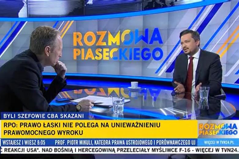 Zrzut ekranu programu telewizyjnego przedstawiający RPO Marcina Wiącka siedzącego w studiu telewizyjnym
