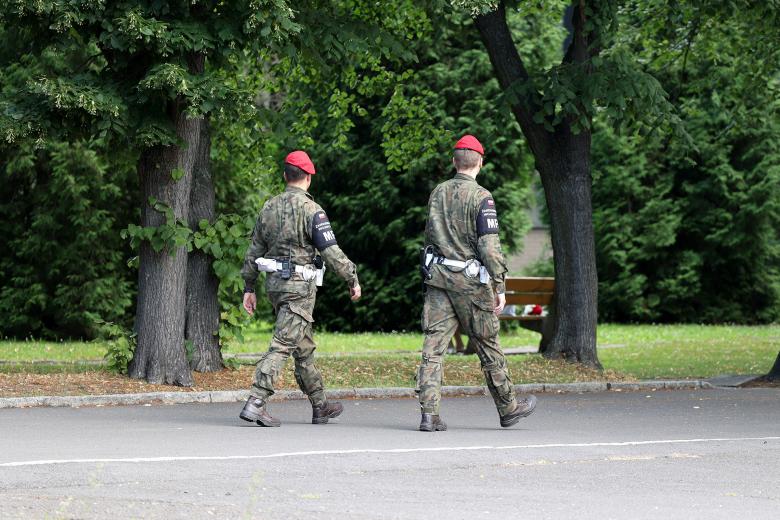 Dwóch funkcjonariuszy Żandarmerii Wojskowej patroluje park