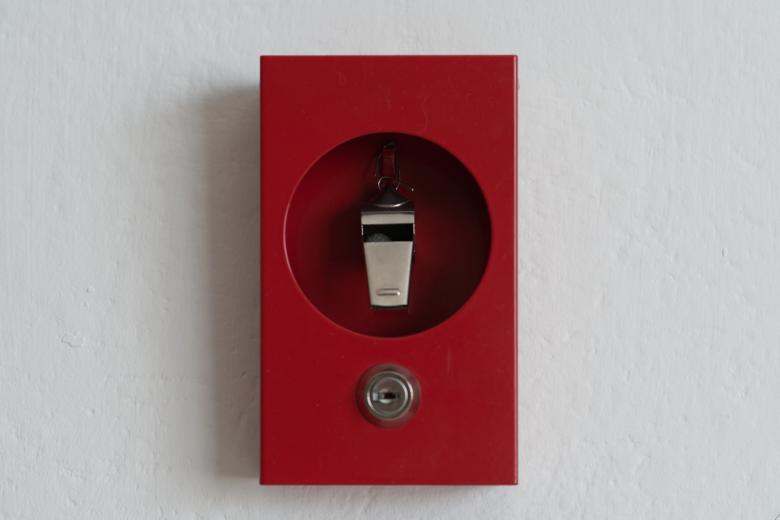 Gwizdek sygnalisty w skrzynce alarmowej, podobnej do tych, w których umieszczane są włączniki alarmu przeciwpożarowego