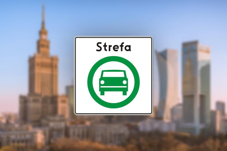  Znak drogowy D-54 „strefa czystego transportu” przedstawiający zielone auto w obręczy nałożony na tło panoramy śródmieścia Warszawy