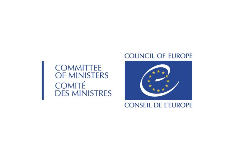 Plansza przedstawiająca logo Rady Europy - 12 żółtych gwiazd na granatowym tle wraz z napisem "Committee of Ministers - Council of Europe"