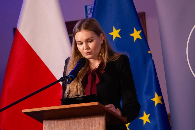 Anna Koperska wypowiada się stojąc przy podium