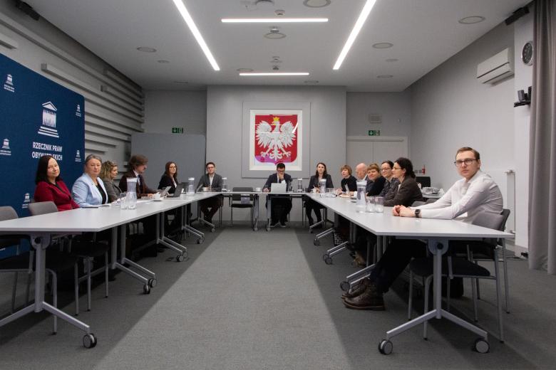 Sala konferencyjna, ludzie siedzący przy stole