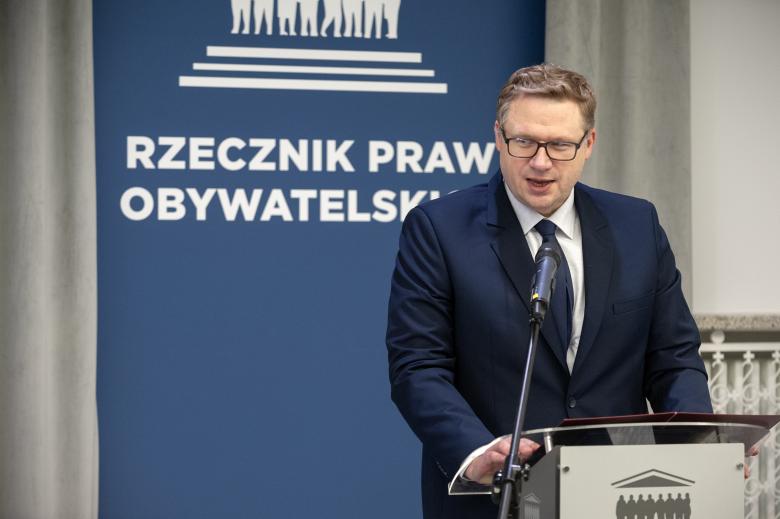 Jakub Gołąb wypowiada się, stojąc przy mównicy 