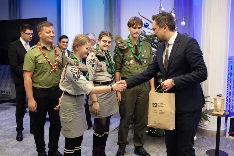 Marcin Wiącek dziękuje czterem harcerzom, w tle choinka