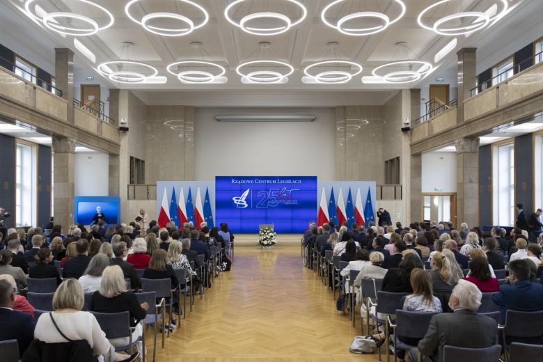 sala z siędzącymi osobami widzianymi od tyłu 