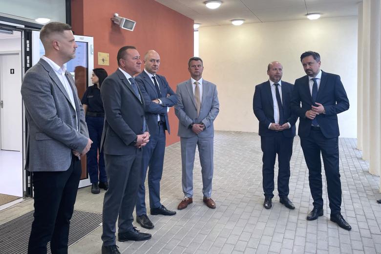 Kilka osób stoi na korytarzu i rozmawia