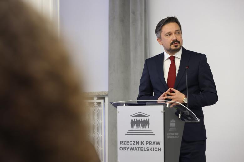 Osoba przemawia za mównicą z napisem "Rzecznik Praw Obywatelskich"
