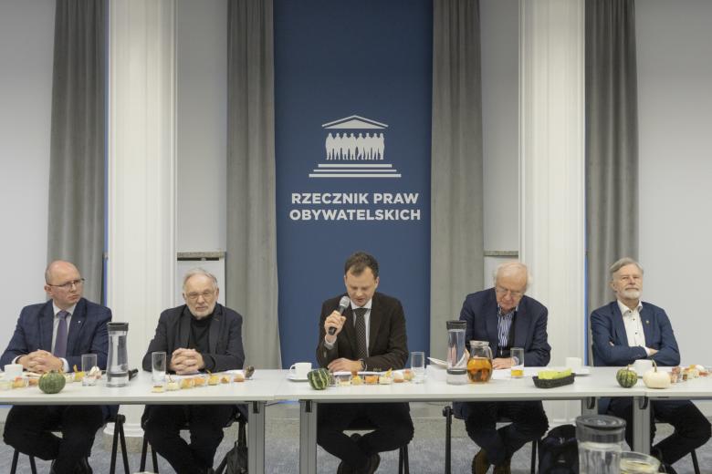 Pięć osób siedzi za stołem na tle napisu "Rzecznik Praw Obywatelskich"