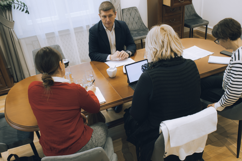 Cztery osoby siedzą przy stole i rozmawiają