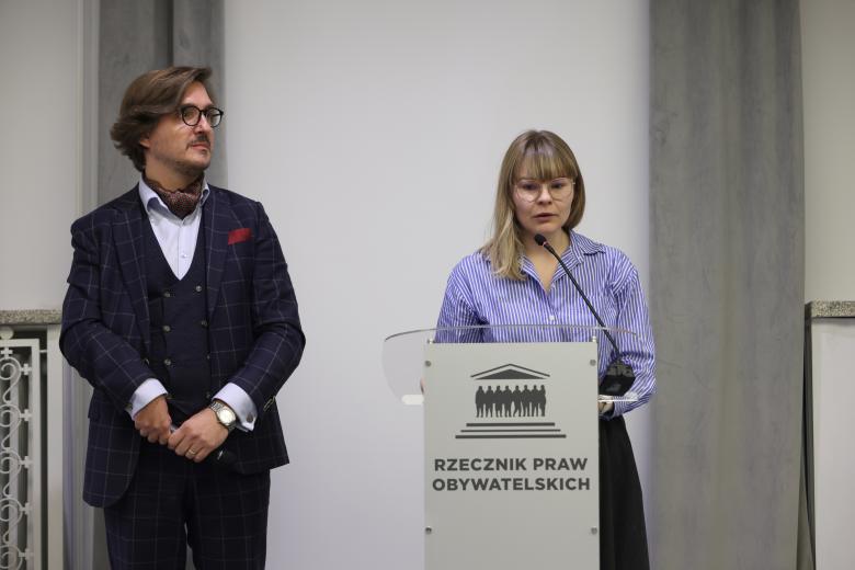 Piotr Zakrzewski oraz Dominika Czerniak stoją przy mównicy w sali konferencyjnej