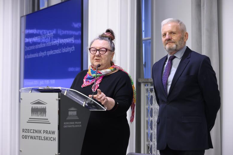 Barbara Imiołczyk i Dariusz Supeł stoją przy mównicy w sali konferencyjnej