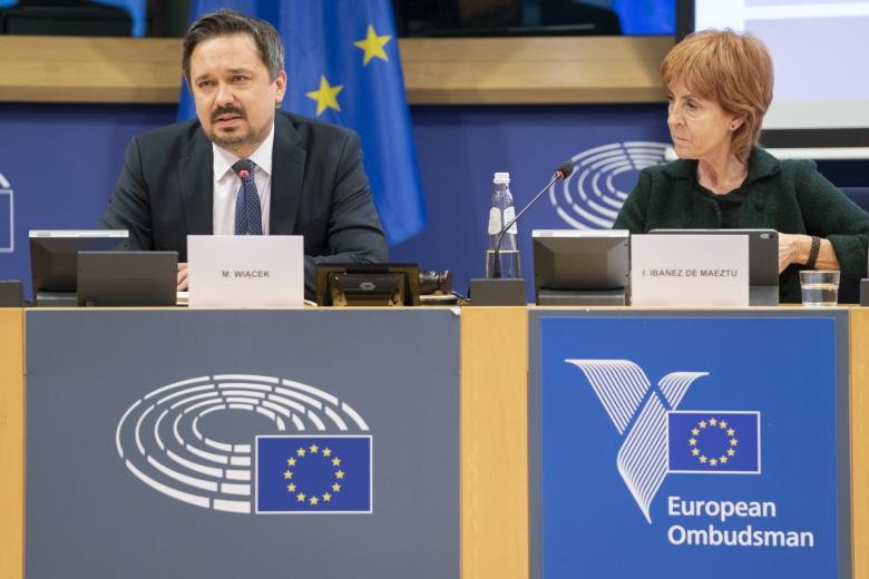 dwie osoby siedzą w sali 