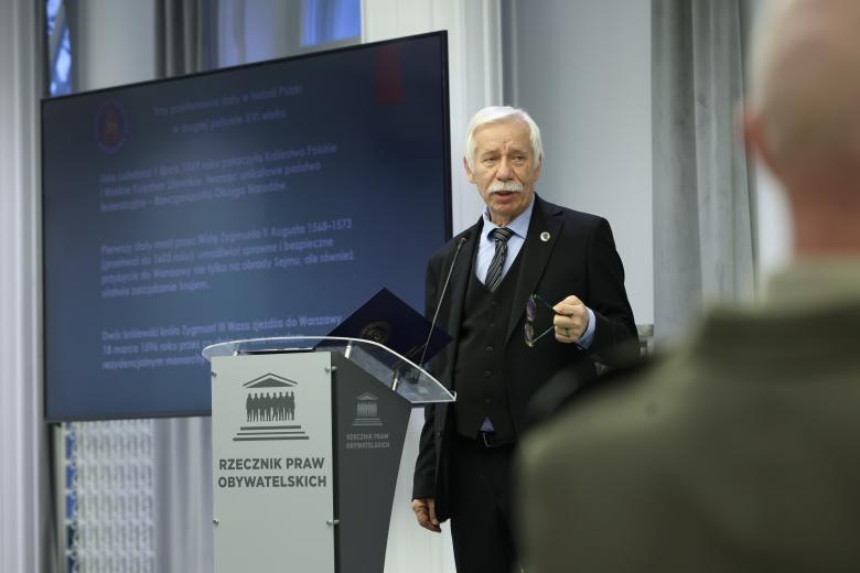 Włodzimierz Dembiński wypowiada się stojąc przy mównicy