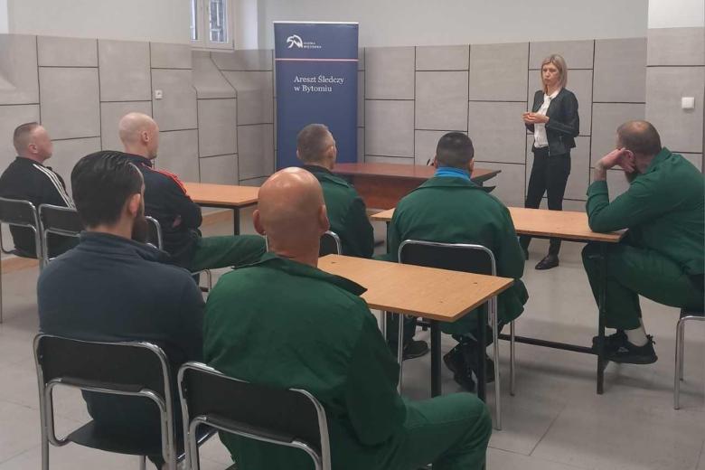 osoby siedzą w sali jedna przemawia