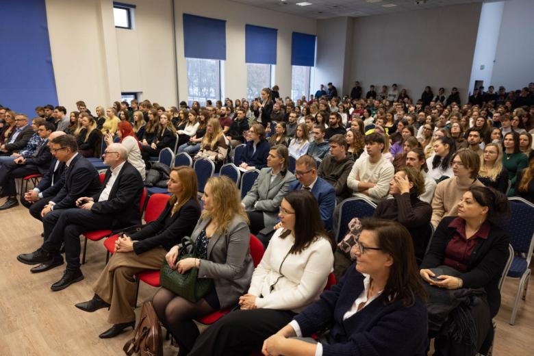 Kilkaset osób siedzi na sali wykładowej