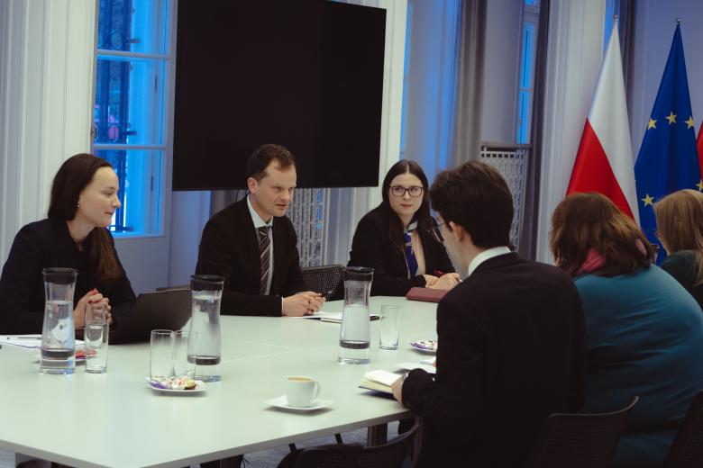 Sześć osób rozmawia przy stole konferencyjnym